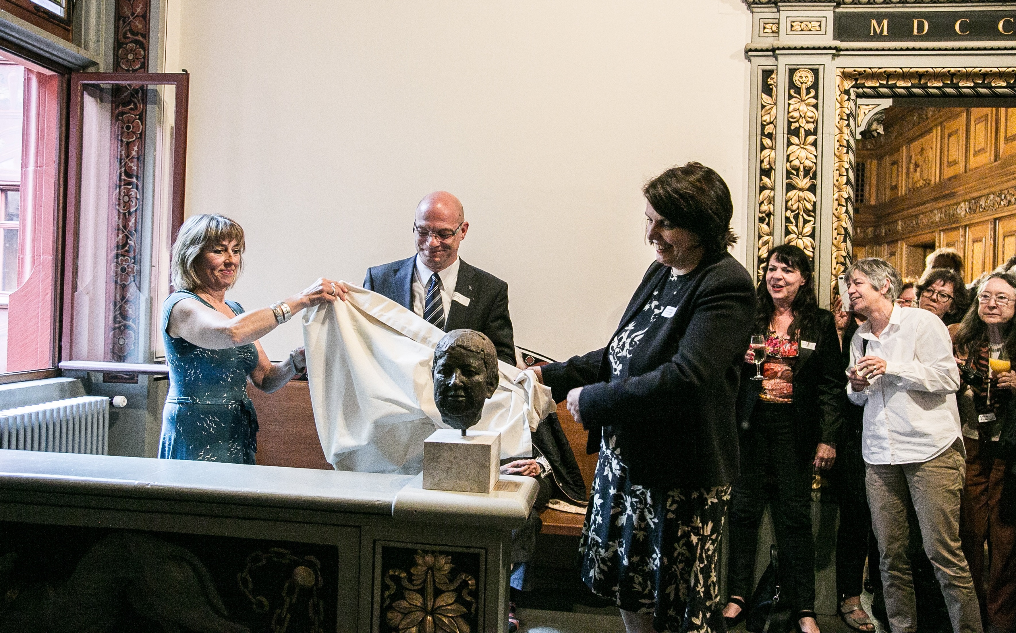Grossrätin Dominique König, Grossratspräsident Remo Gallacchi und Regierungspräsidentin Elisabeth Ackermann enthüllen im Rathaus die Büste von Gertrud Spiess. 