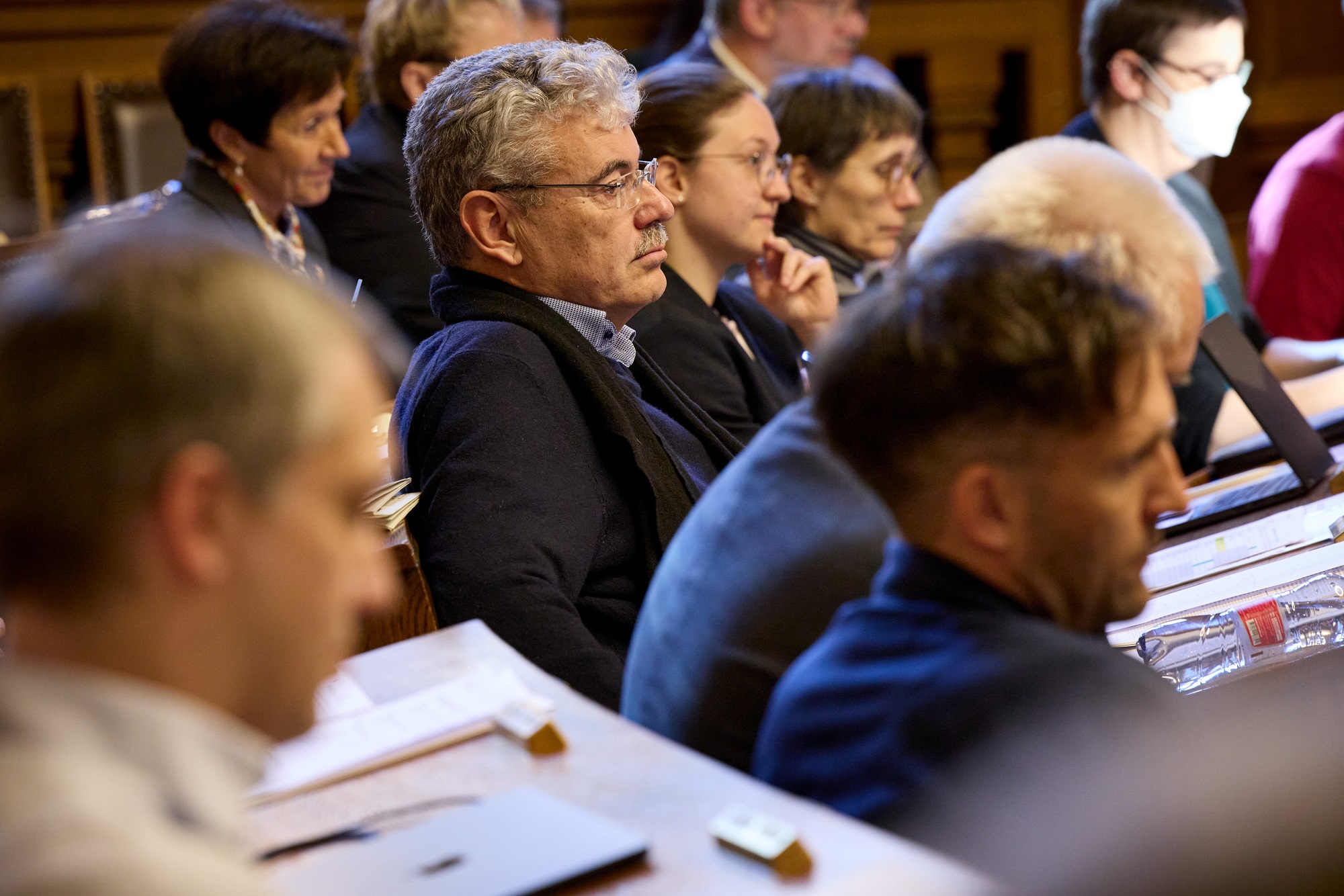 Zehn Grossratsmitglieder sitzen konzentriert und ziemlich dicht gedrängt im Grossratssaal.