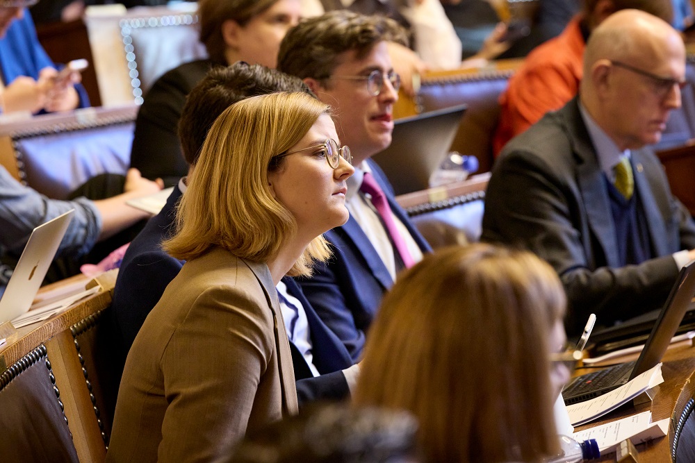 Zwei Grossrätinnen und zwei Grossräte auf ihren Sitzen während einer Grossratssitzung.